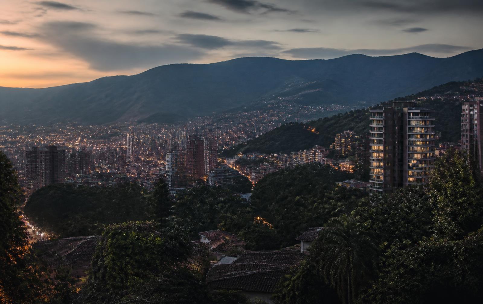 Medellín El Poblado at dusk with apartment towers and green mountains